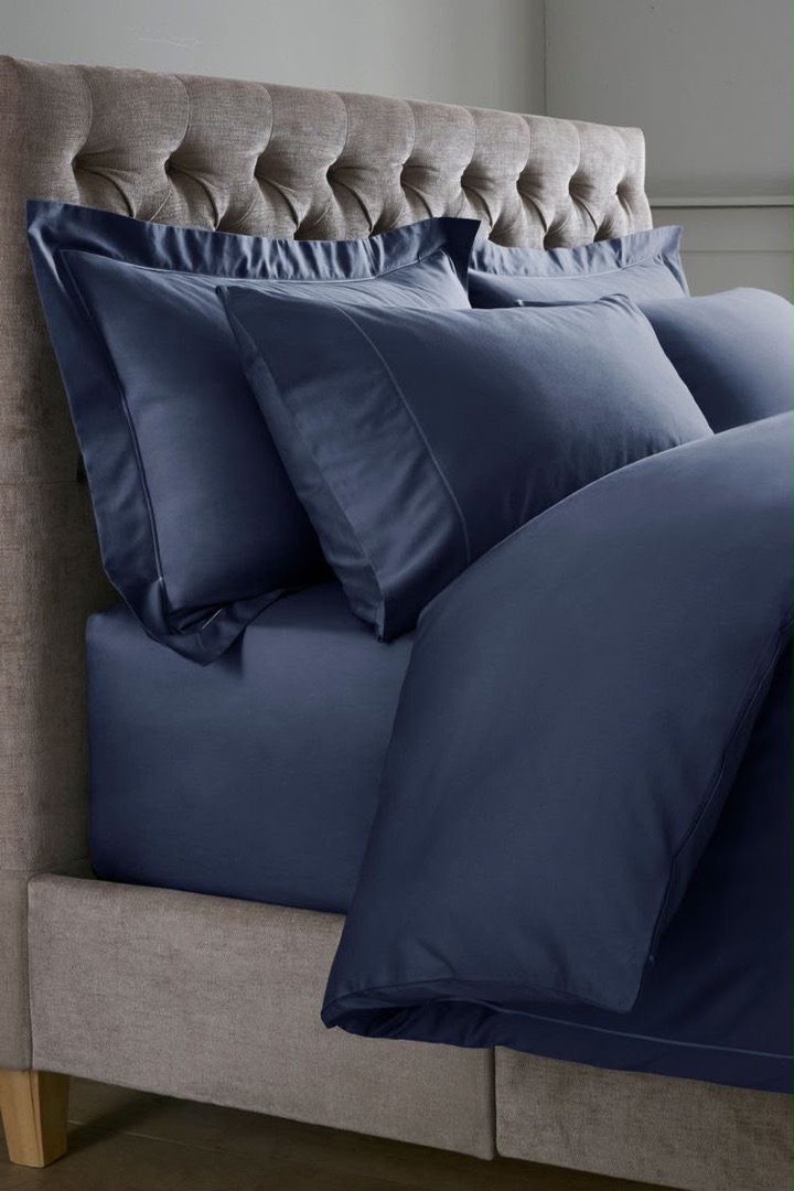Midnight navy bedding set on an upholstered grey bed