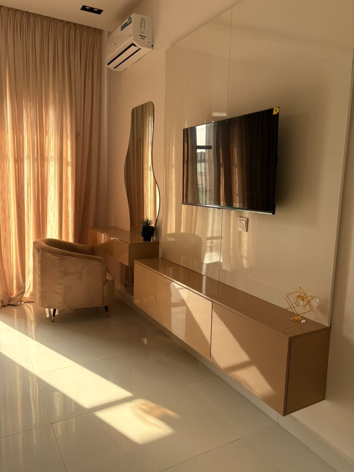 Warm bedroom with timber media console and curtains
