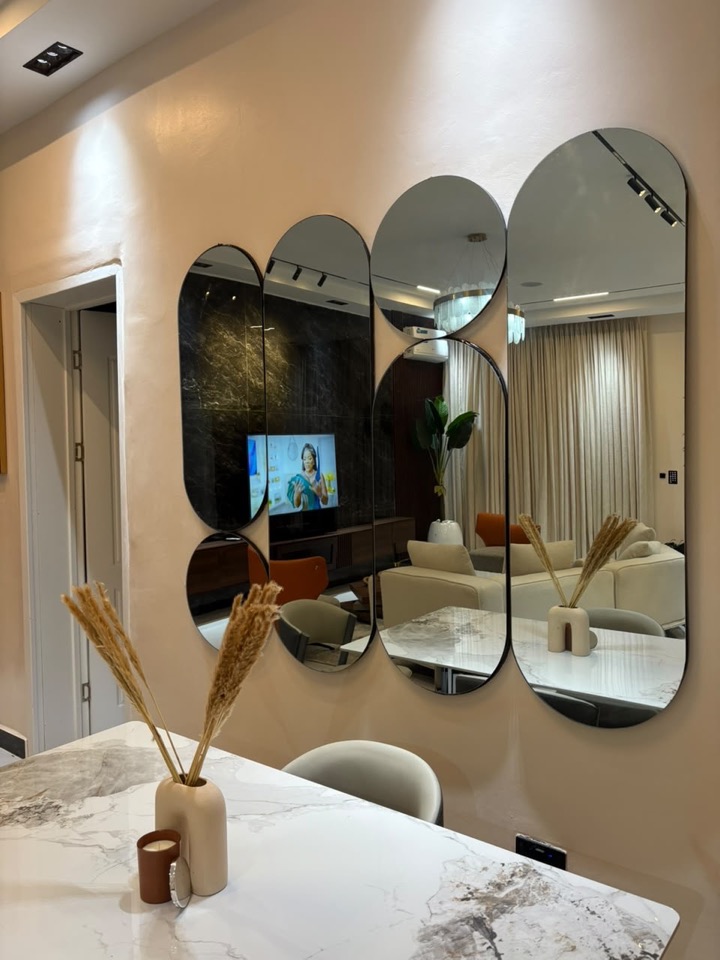 Dining area with arched sculptural mirrors and a marble table