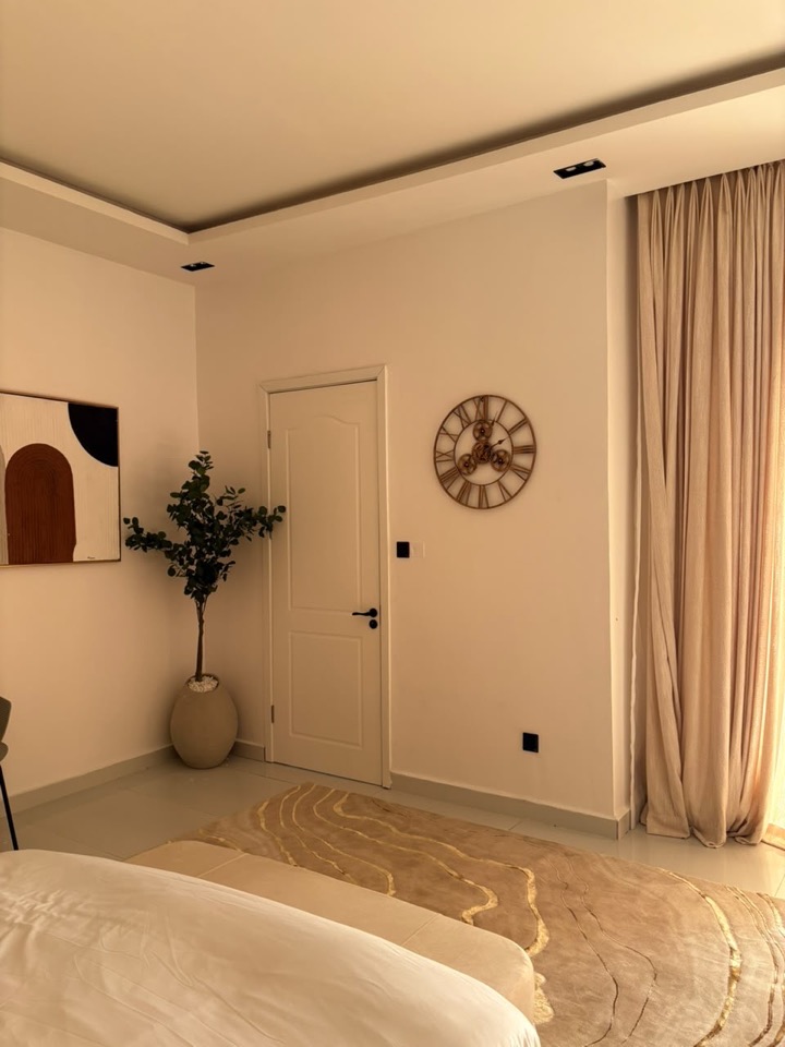 Entrance hall with an arched mirror, sculpted console and a tall plant