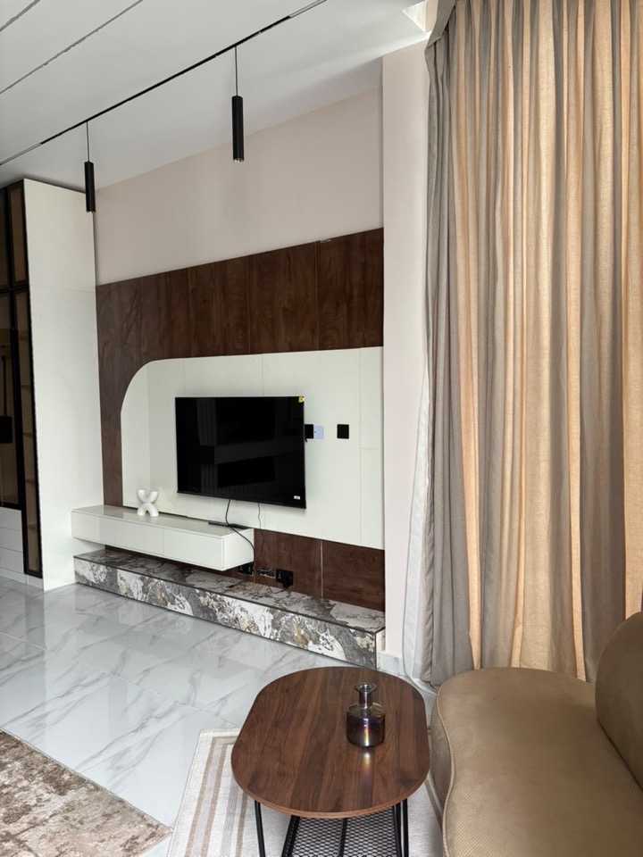 Bright living room with a walnut-clad media wall and soft white seating