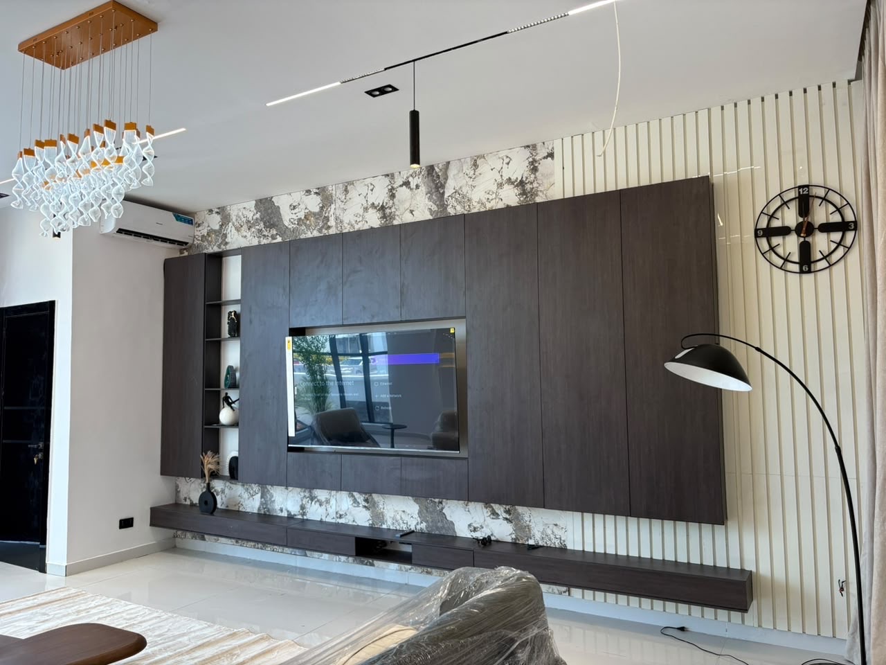 Wide view of a Project Hampton living space with a walnut media wall and soft seating