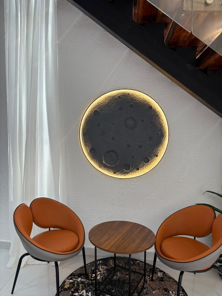 Reading corner with a backlit round mirror and two orange chairs